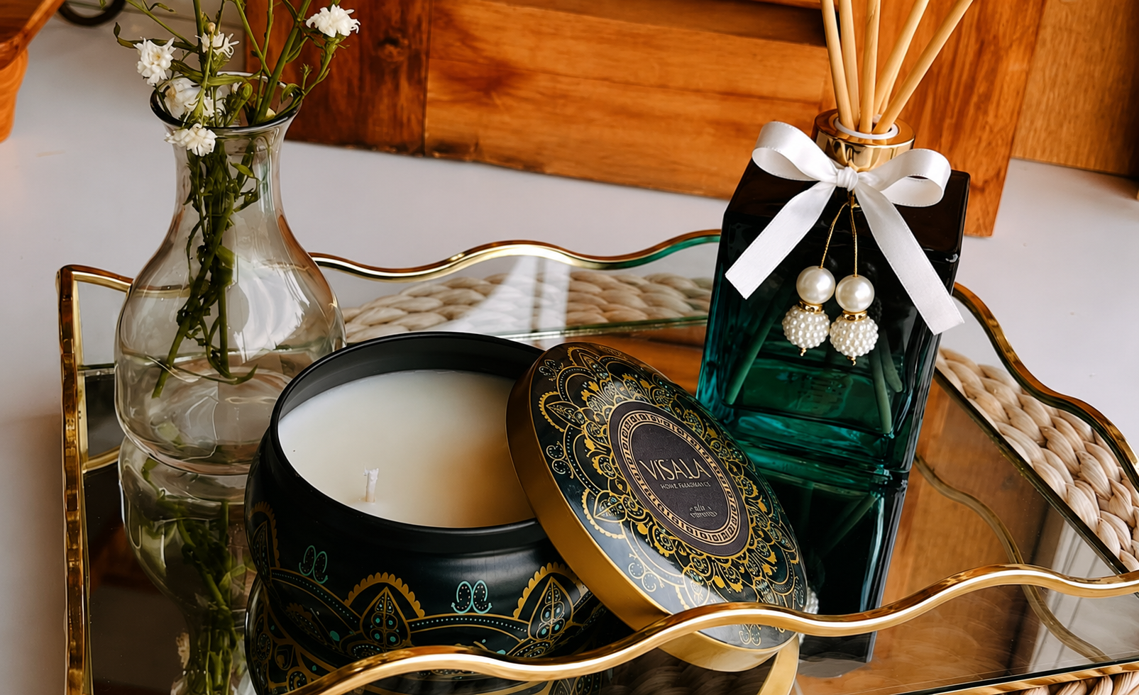 Vela aromática Visalá e difusor de varetas decorado com laço branco em bandeja espelhada